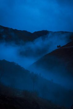 the mountains are covered in fog at night