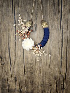 a blue moon with flowers hanging from it's side on a wooden wall next to a string