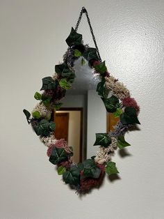 a mirror hanging on the wall next to a wreath