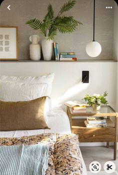 a bed room with a neatly made bed and a plant on the shelf above it