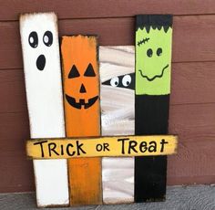 a wooden sign that says trick or treat with two pumpkins and ghost faces on it