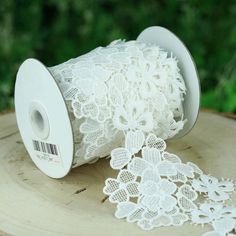 a roll of white lace sitting on top of a tree stump