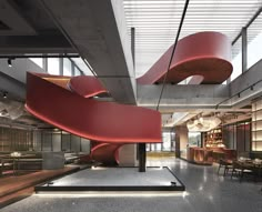 the interior of a modern office building with large red spiral staircase in front of it