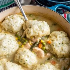 a pot filled with chicken and dumplings on top of a wooden table