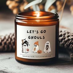 a candle that says let's go ghouls with three ghostes on it