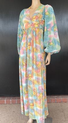 1970s maxi dress. Predominantly green multicolor silky nylon or polyester. Empire waist. Tie belt attached on front wraps to back to tie. Skirt gathered only under front belt. Sleeves have elastic cuffs. Nylon zip back. Measurements are  32" bust 24" waist Up to 50" hips 14" bodice length 59" length 28" sleeves 10" shoulders Pretty dress presents well exhibiting very minimal to no obvious wear. Retro Multicolor Maxi Dress For Spring, Retro Green Long Sleeve Maxi Dress, Green Long Sleeve Retro Maxi Dress, Retro Green Floral Print Maxi Dress, Retro Multicolor Floral Print Maxi Dress, Multicolor Retro Maxi Dress With Floral Print, Green Retro Maxi Dress With Floral Print, Vintage Multicolor Maxi Dress For Beach, Flowy Vintage Multicolor Dresses