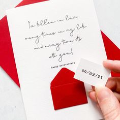 a hand holding a red envelope with a note attached to it