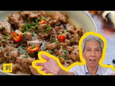 an old man is holding his hands out in front of a plate of food with meat and vegetables on it