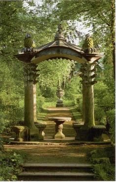 a gazebo in the middle of a forest with steps leading up to it and statues on either side