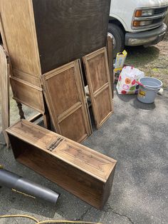 several pieces of wood sitting next to each other on the ground near a van and trash can