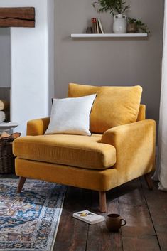 a yellow chair sitting on top of a wooden floor next to a fire place in a living room