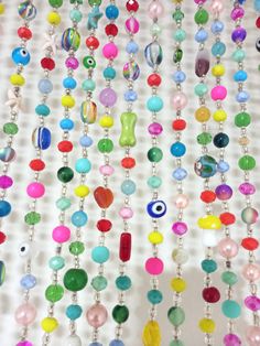 colorful beads hanging from a white wall