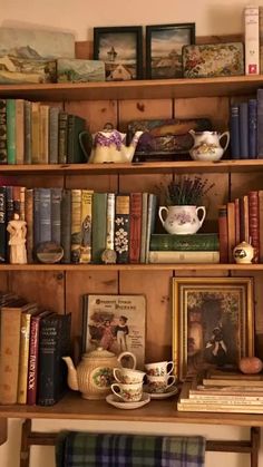 there are many books and tea cups on the shelves in this room, all lined up