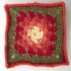 a crocheted square with red and green accents