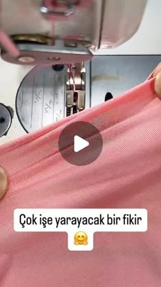 someone is using a sewing machine to sew something on the pink fabric that they are wearing