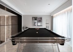 a pool table in the middle of a room with pictures on the wall behind it