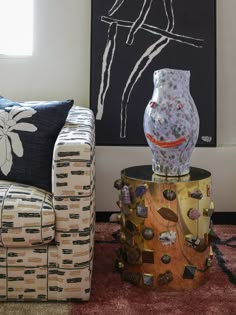 a living room filled with furniture and a painting on the wall