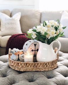 a tray with flowers and candles on top of a couch