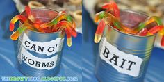 two tin cans filled with gummy bears sitting on top of a blue tablecloth