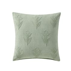 a light green pillow with embroidered flowers on the front and back, sitting on a white background