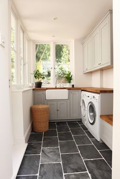 a washer and dryer in a small room with tile flooring on the walls