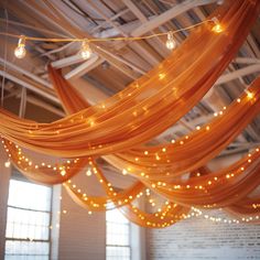 an orange drape with lights hanging from it