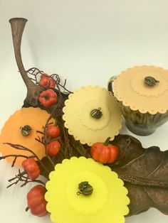 an arrangement of flowers and leaves on a white surface