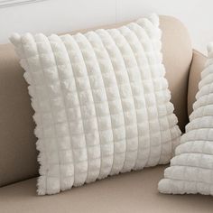 two pillows sitting on top of a couch next to each other