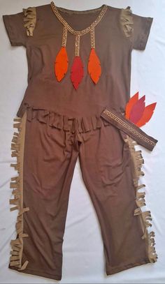 a baby's brown outfit with orange feathers on it