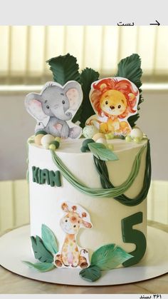 a three tiered cake decorated with animals and leaves