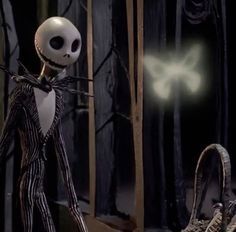 a skeleton dressed as jack skellings in front of a basket with a glowing face