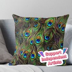 a pillow with the words support independent artists on it and a colorful peacock feather pattern