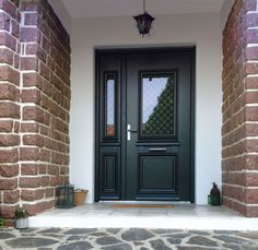 the front door to a house with brick pillars