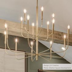 a chandelier hanging from the ceiling in a room with white walls and wooden beams