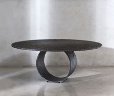 a black table sitting on top of a cement floor next to a white brick wall