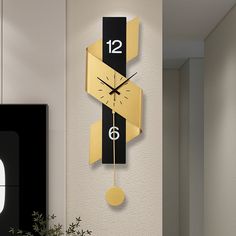 a clock that is on the wall next to a potted plant in a room