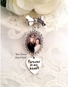 a white rose and a silver heart shaped keychain with a photo on it