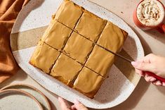 someone is cutting into a square cake on a plate