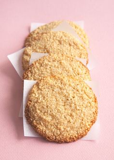 two cookies sitting on top of each other next to a pink tablecloth and white napkins