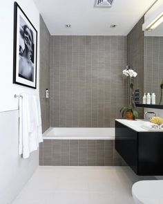 a bathroom with a sink, toilet and bathtub next to a mirror on the wall