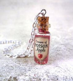 a tiny bottle necklace with a chain attached to it's side and the message, because of prison apple