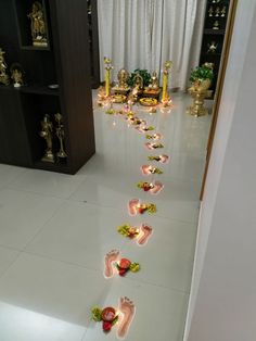 there is a long line of footprints on the floor in front of candles and other decorations