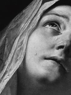 a black and white photo of a woman's face with tears on her nose