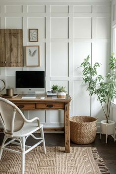 a desk with a computer on top of it next to a chair and potted plant