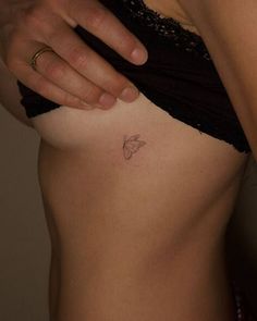 a woman's stomach with a butterfly tattoo on her left side, and the bottom part of her abdomen visible