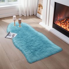 a living room with a fireplace and blue rugs on the floor in front of it