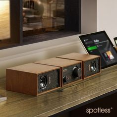 two speakers sitting on top of a table next to a laptop