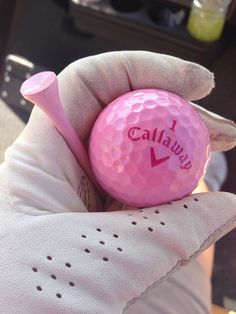 a pink golf ball in someone's hand with the word california written on it