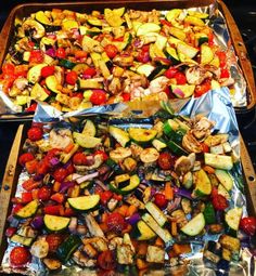 two trays filled with different types of vegetables on top of metal foil covered baking pans