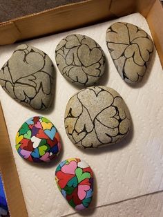 four painted rocks sitting on top of a box